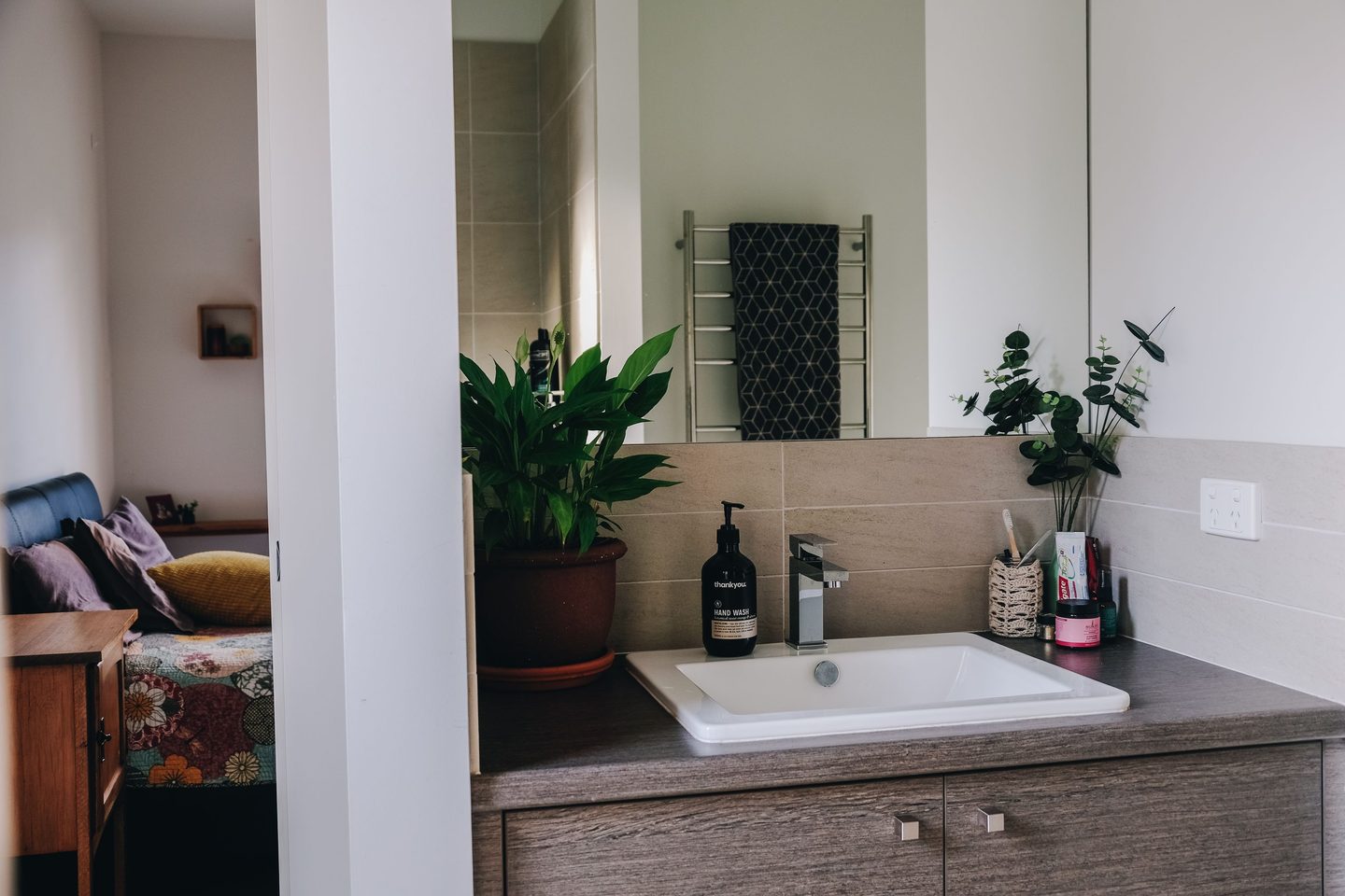 Baño con lavamanos, toallero y plantas