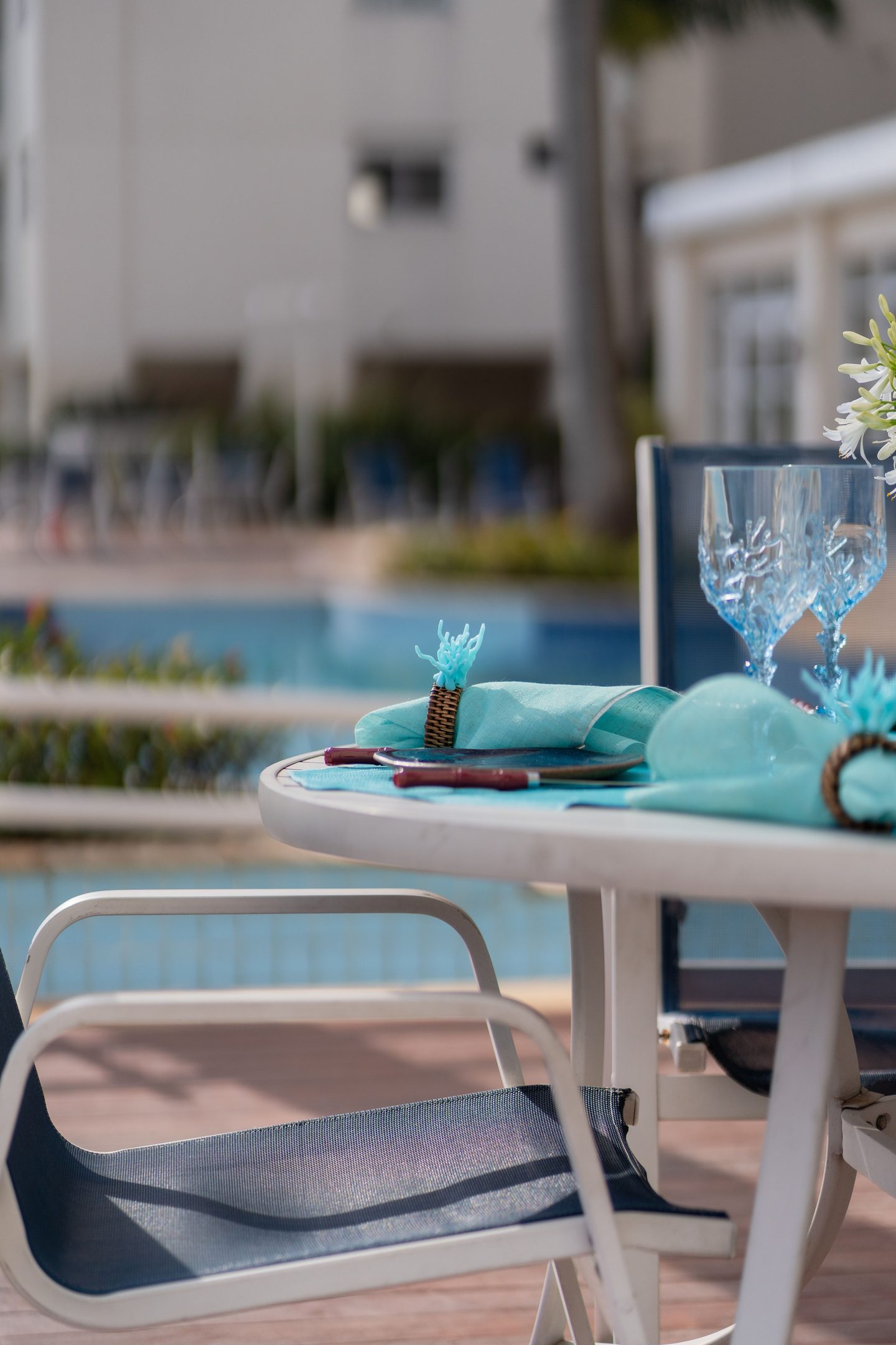 Mesa con copas y vajilla junto a la piscina