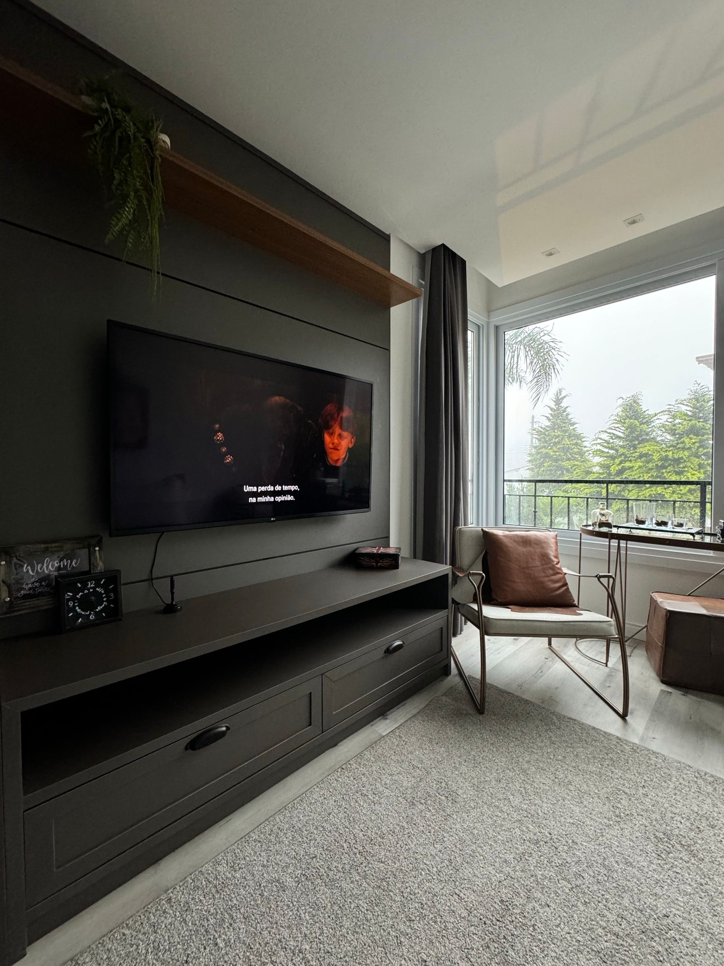 Sala con mueble de TV oscuro y salida al balcón